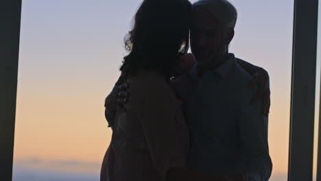 happy-mature-couple-dancing-at-home-enjoying-successful-relationship-having-fun-celebrating-anniversary-retirement-on-vacation-at-sunset