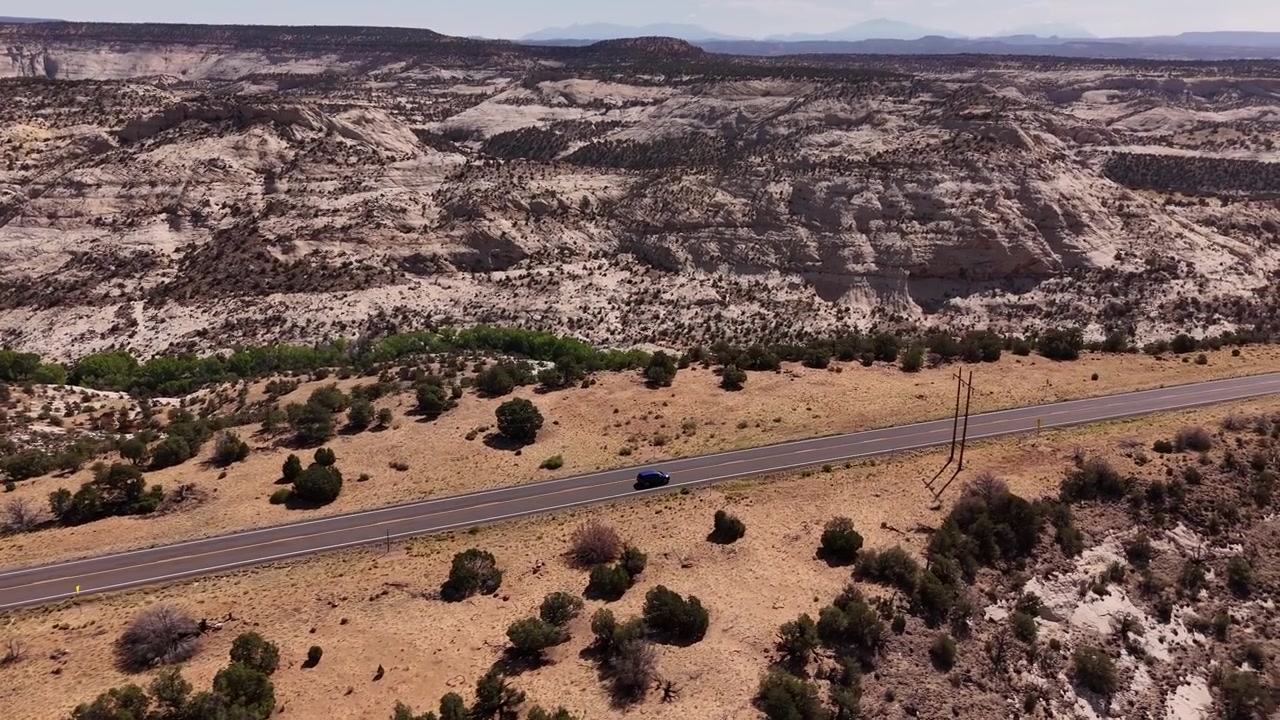 Drone che riprende un'auto di lato che percorre la strada panoramica americana UT12 nello Utah in 4k