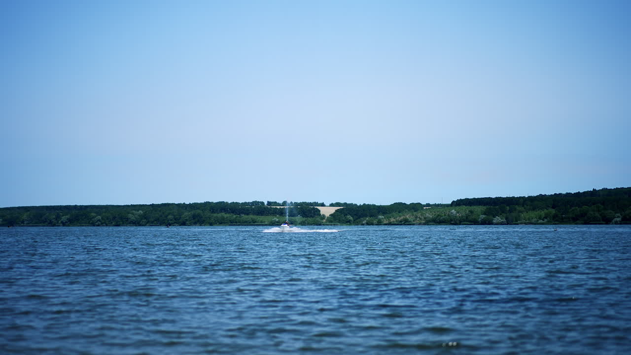 Jet ski riding by the river on sunny day. Summer time activities on water. Extreme water sport.
