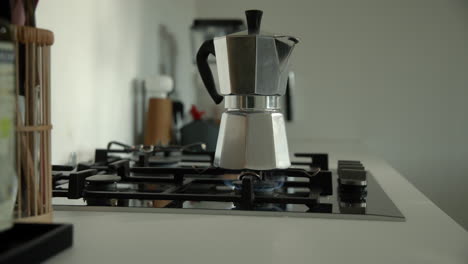 traditional bialetti moka express coffee maker brewing coffee on a gas stove in the morning