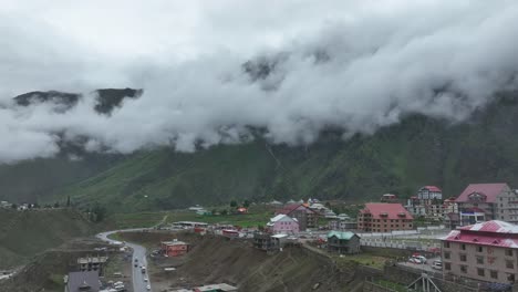 Toma-Aérea-Descendente-Del-Hermoso-Pequeño-Pueblo-De-Batakundi-En-La-Región-Norte-De-Pakistán-En-Un-Día-Nublado