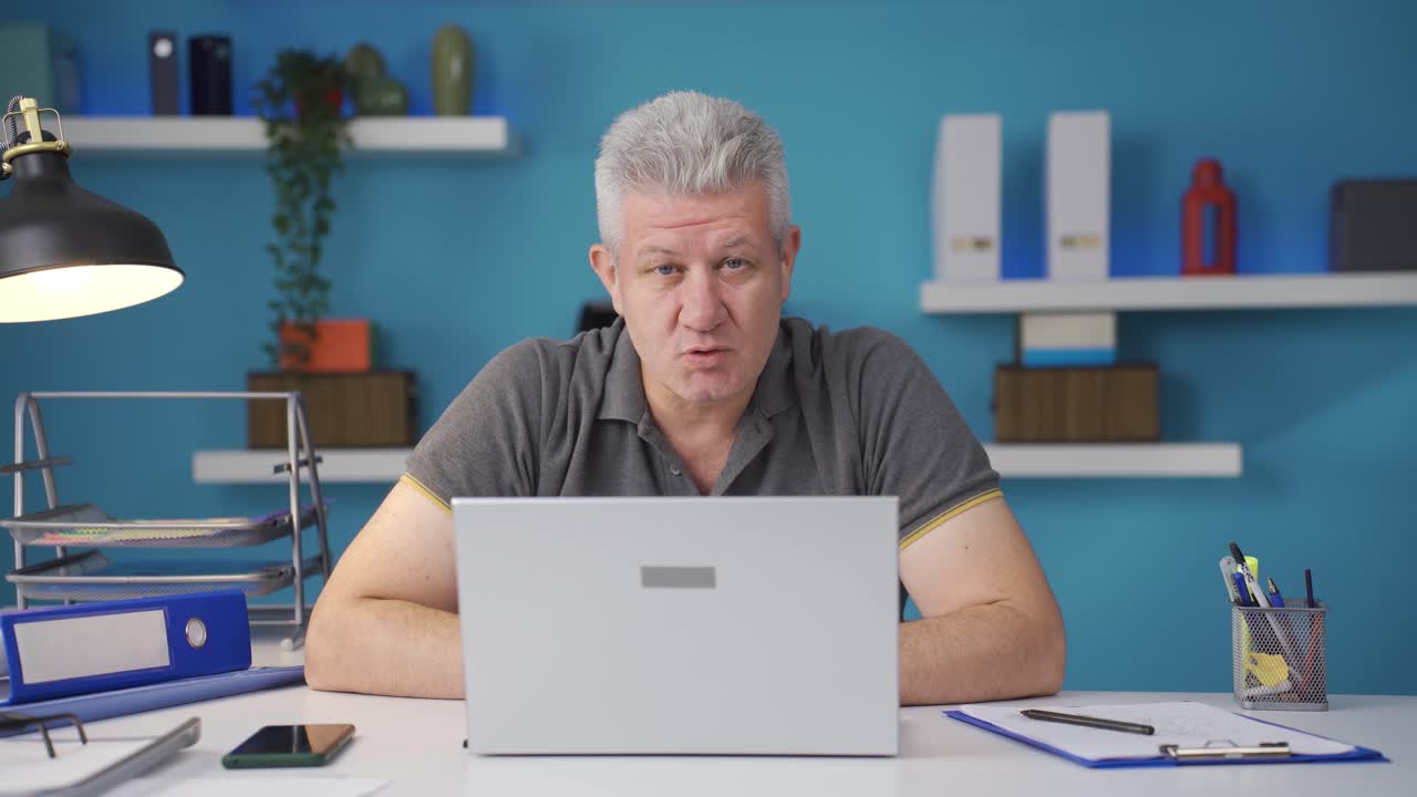 Homeoffice-Mitarbeiter telefoniert per Video und blickt in die Kamera