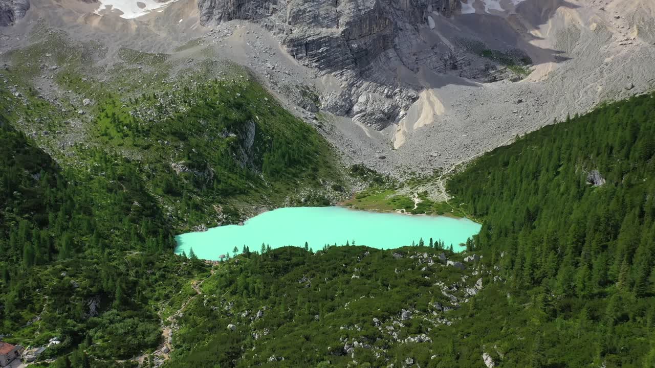 Lake Sorapis bright turqoise water in the Dolomites Italy, forward aerial