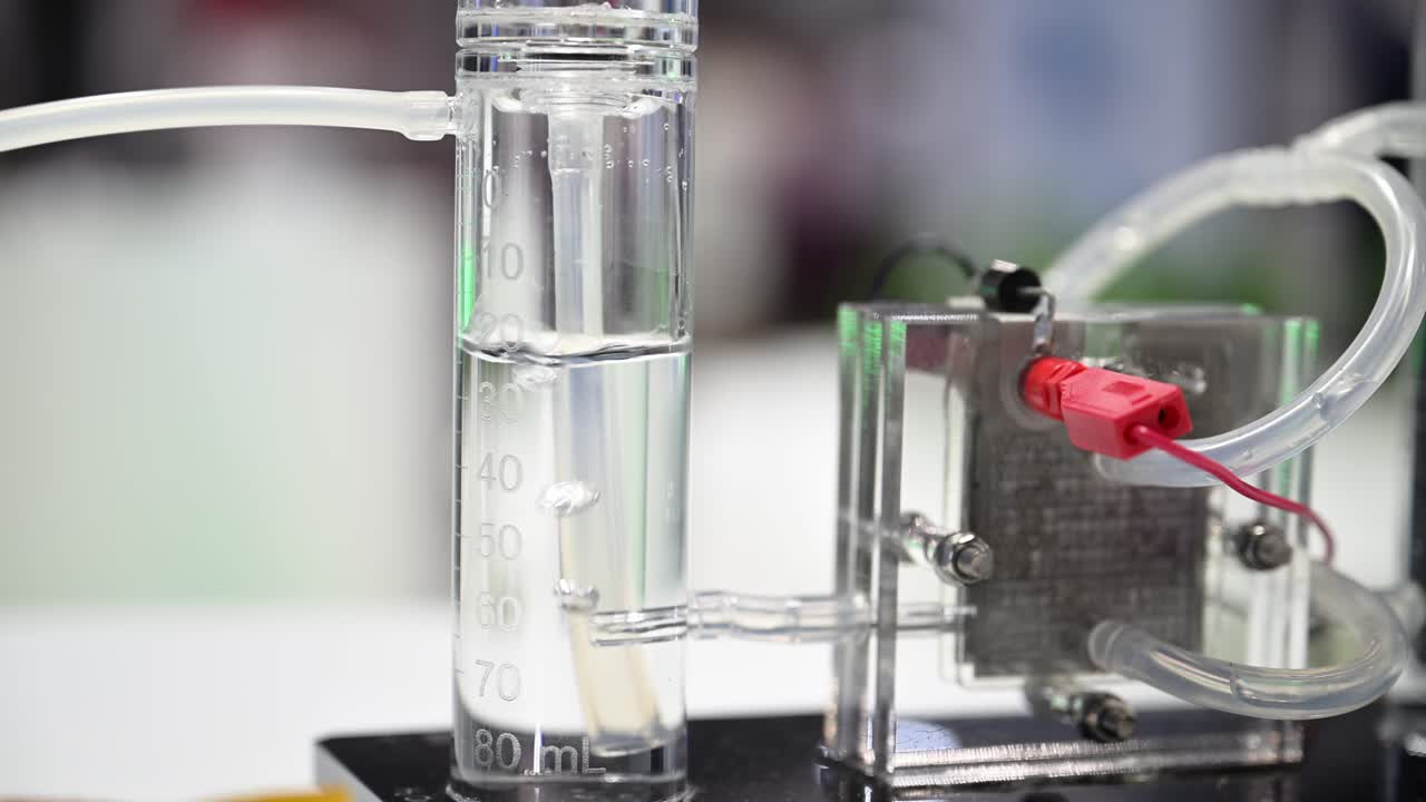 burbujas de hidrógeno que se forman en un cilindro de plástico lleno de agua, un demostrador de células de combustible divide el agua en oxígeno e hidrógeno