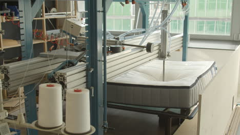 mattress being tested with hydraulic press in mattress production facility - wide