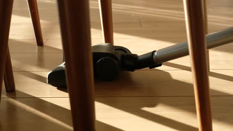 close-up of a vacuum cleaner under a chair in a sunny room