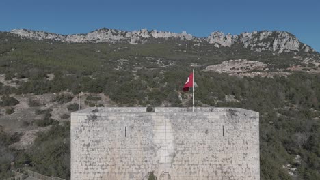 Vista-De-Drones-De-La-Bandera-En-La-Cima-Del-Castillo-Entre-Los-árboles-En-La-Cima-De-La-Montaña,-Castillo-De-Belenkeşlik,-Pavo