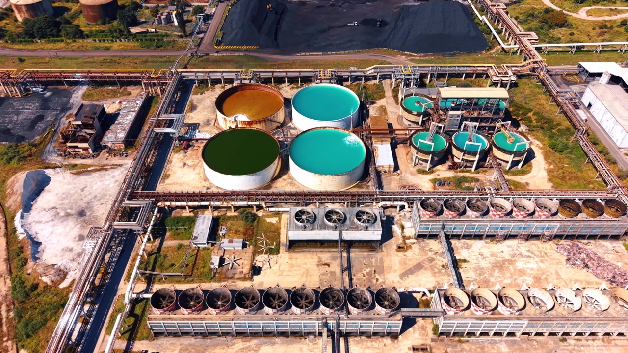 Industrial site with large storage tanks. In an industrial area, large storage tanks hold different colored liquids during daylight hours.