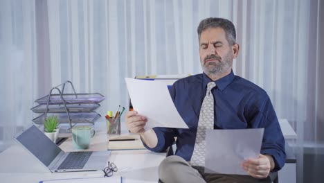 hombre de negocios maduro mirando los documentos trabajando muy cuidadosamente.