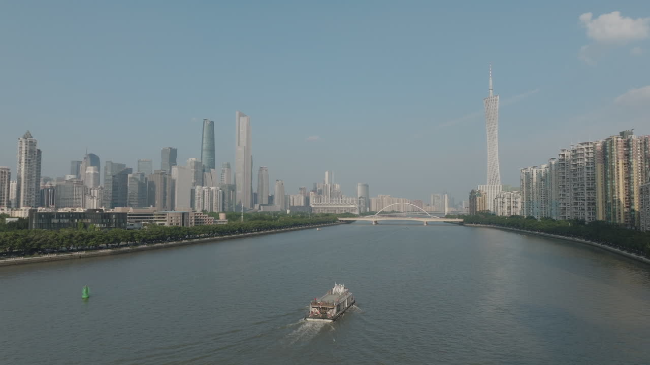 Aufsteigende Luftaufnahme mit Fokus auf einer Fähre auf dem Fluss im Stadtzentrum von Guangzhou, China