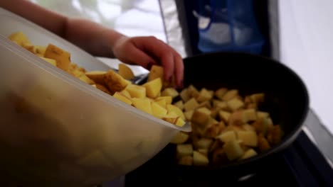 verter patatas en rodajas en una sartén