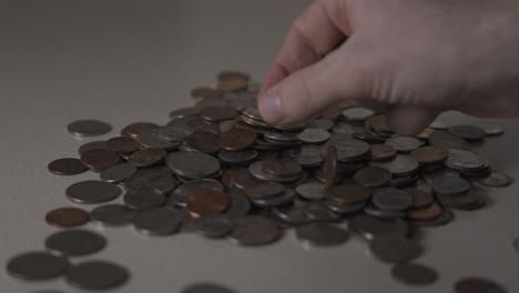 recogiendo algo de cambio de una pila de monedas con poca luz