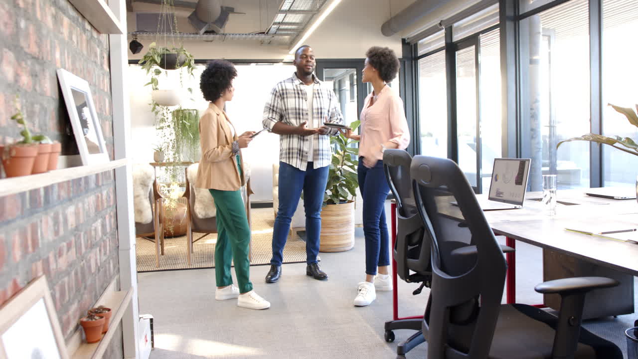 Professionals discussing teamwork in a modern, diverse office setting