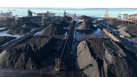 puerto de carbón con grúas de carga, transportadores, existencias y un carguero a granel