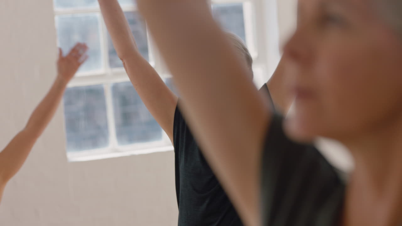 класс йоги красивая пожилая женщина практикует позу воина медитация наслаждаясь группой физическая тренировка в студии