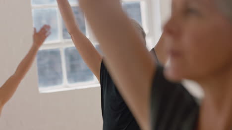 Yoga-Klasse-Schöne-Alte-Frau-Praktiziert-Krieger-Pose-Meditation-Und-Genießt-Das-Körperliche-Fitnesstraining-In-Der-Gruppe-Im-Studio