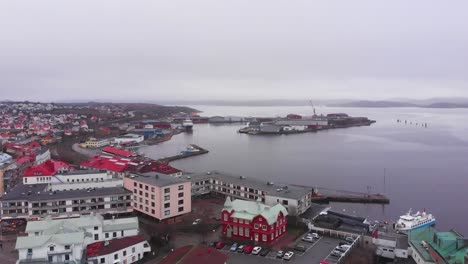 Flying-over-the-colorful-and-peaceful-city-of-Lysekil,-Sweden-situated-by-the-calm,-serene-waters---Aerial-shot