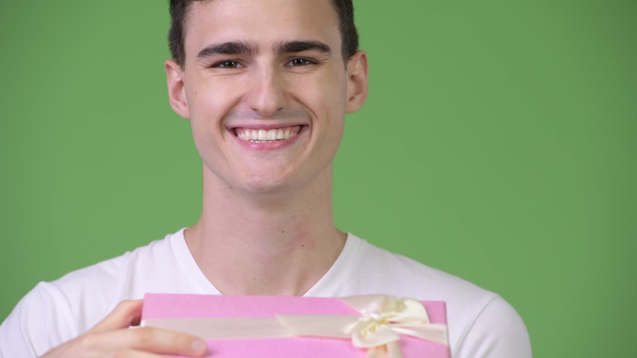 Young happy handsome man opening gift box