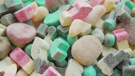 man picks up a single candy from a large candy pile