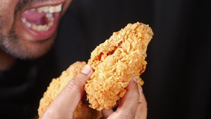 Person eating fried chicken