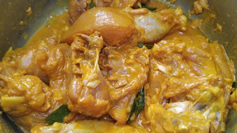 marinated raw chicken pieces infused with rich spices, ready to be cooked to perfection, releasing an irresistible aroma and flavor.