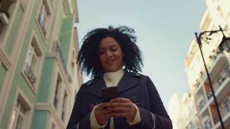 smiling woman holding smartphone walking sunny morning closeup. happy app user.