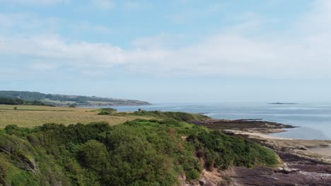 traeth lligwy anglesey coastal shoreline aerial view dolly across scenic welsh weathered coastline