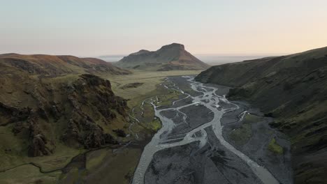 aerial view of a braided river cutting through a remote valley in northern iceland, surrounded by rugged mountains and volcanic terrain