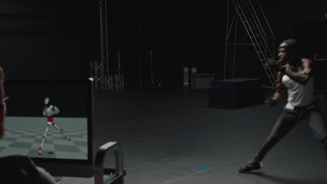 모션 처 슈트를 입은 남자가 스튜디오에서 싸우고 컴퓨터 게임, 무술 배우, 권투, 3d 캐릭터 애니메이션, 가상 현실 싸움 게임.