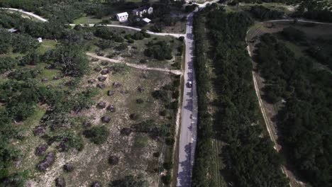 aerial shot of cars driving down texas hill country roads