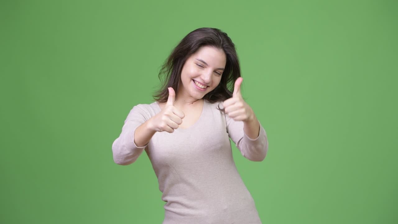 Young happy beautiful woman smiling while giving two thumbs up