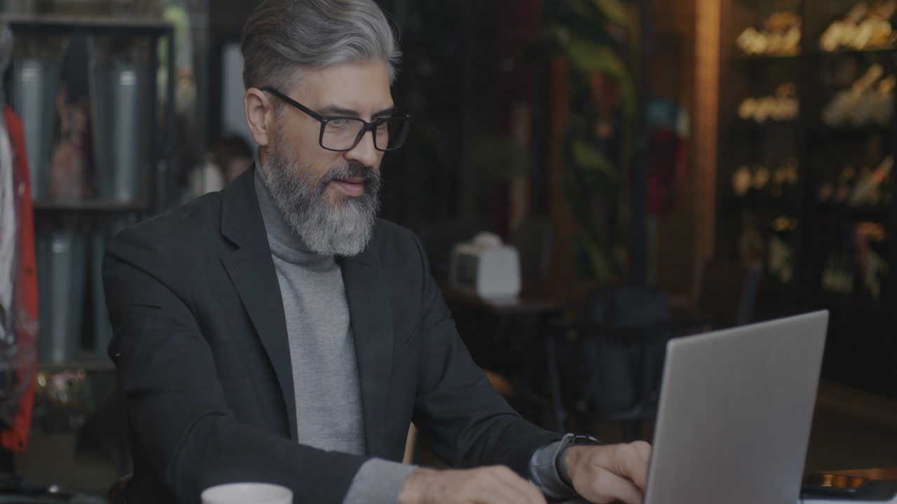 Businessman Working on Laptop in Cafe