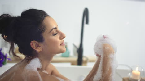 caucasian woman taking bathtub with foam