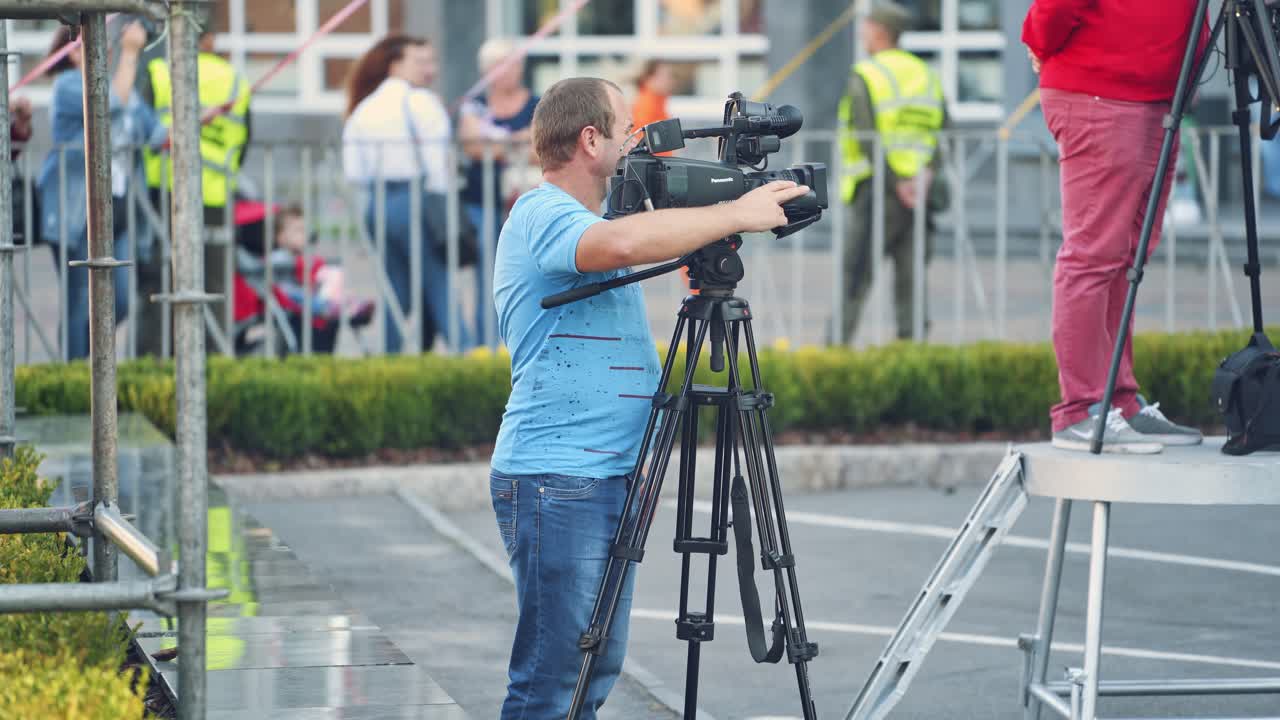 Man with video camera in city. Man with video camera shooting outdoor in the city