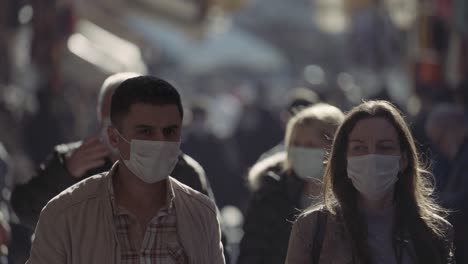 people wearing masks in a crowded city street