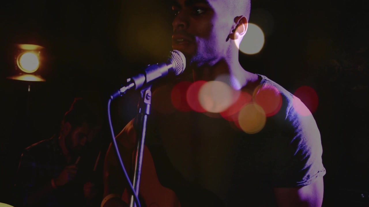 Photographer adjusting DSLR lens on stage focusing on band creating bokeh flares showing music mood