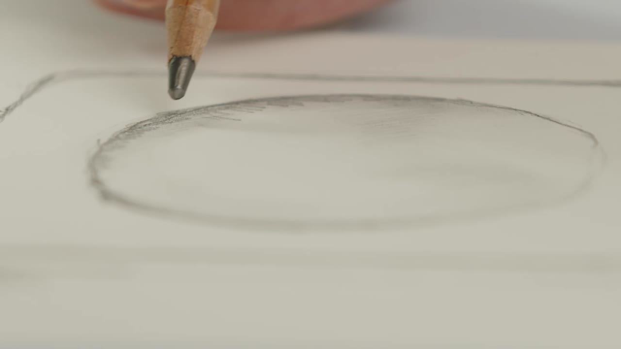 The designer draws a contour and a shadow of a perfume bottle with a pencil - the packaging design process. Close-up shot.