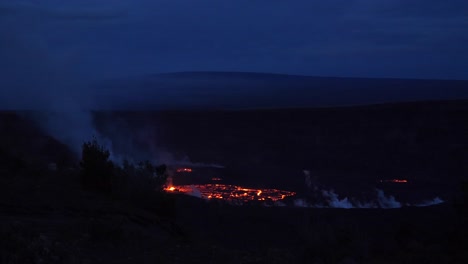 early dawn wide angle of kilauea erupting at its crater with mauna loa volcano on the horizon