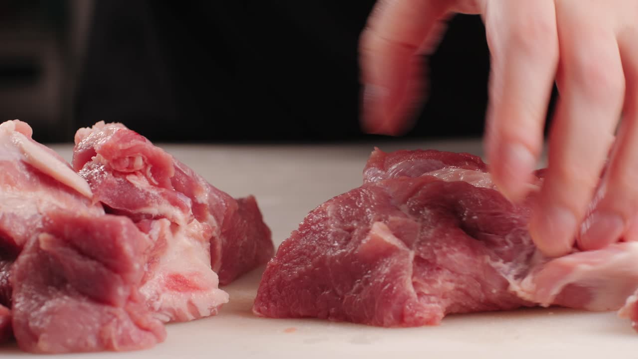 Chef Butcher cutting pork meat with knife on kitchen, cooking Mexican traditional food. Man cut big beef piece for barbecue bbq.