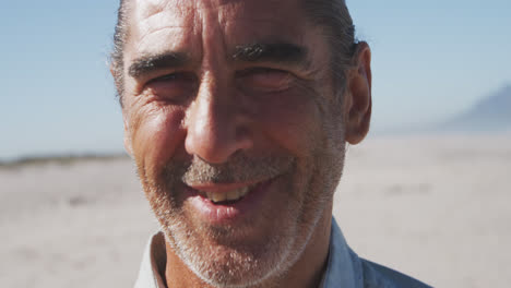 retrato de un hombre caucásico mayor disfrutando del tiempo en la playa