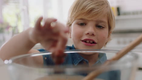 happy little boy tasting delicious chocolate treats in kitchen enjoying homemade sweets having fun on weekend