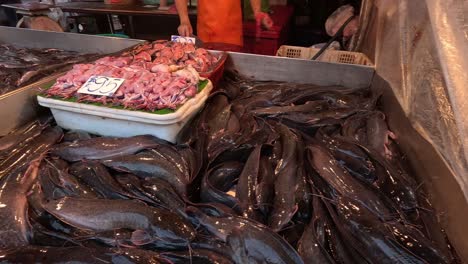 worker arranging fish at a bustling market