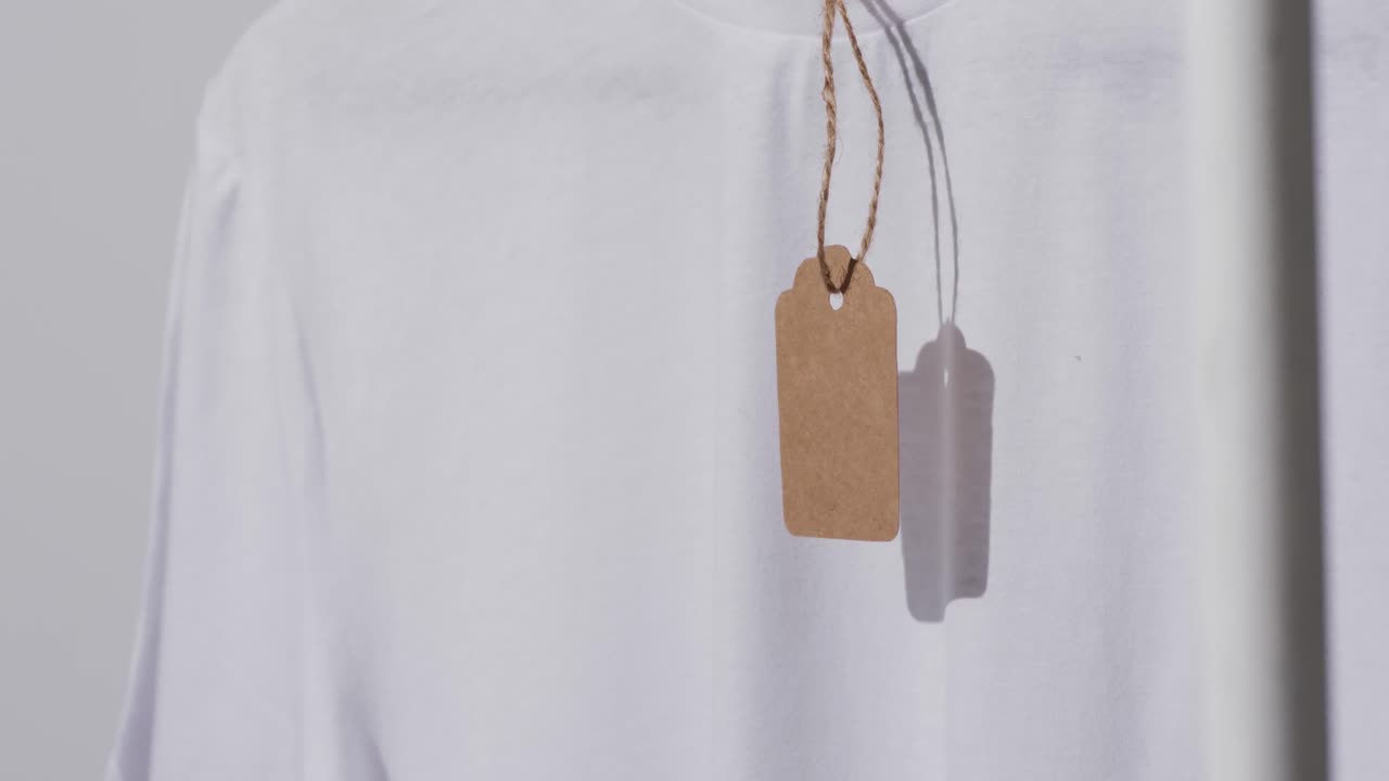 회색 배경에 태그와 복사 공간을 가진  ⁇  티셔츠의 비디오