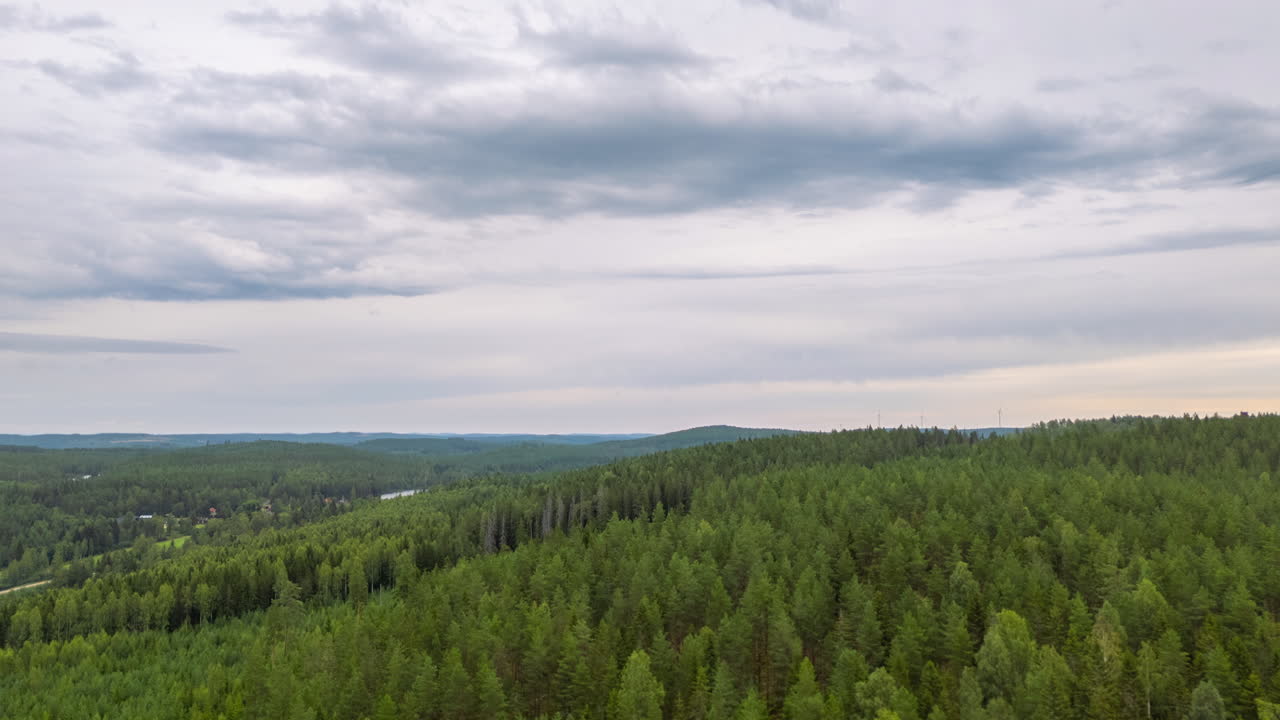 Aerial hyperlapse view over Scandinavian forest tree canopy with drifting clouds