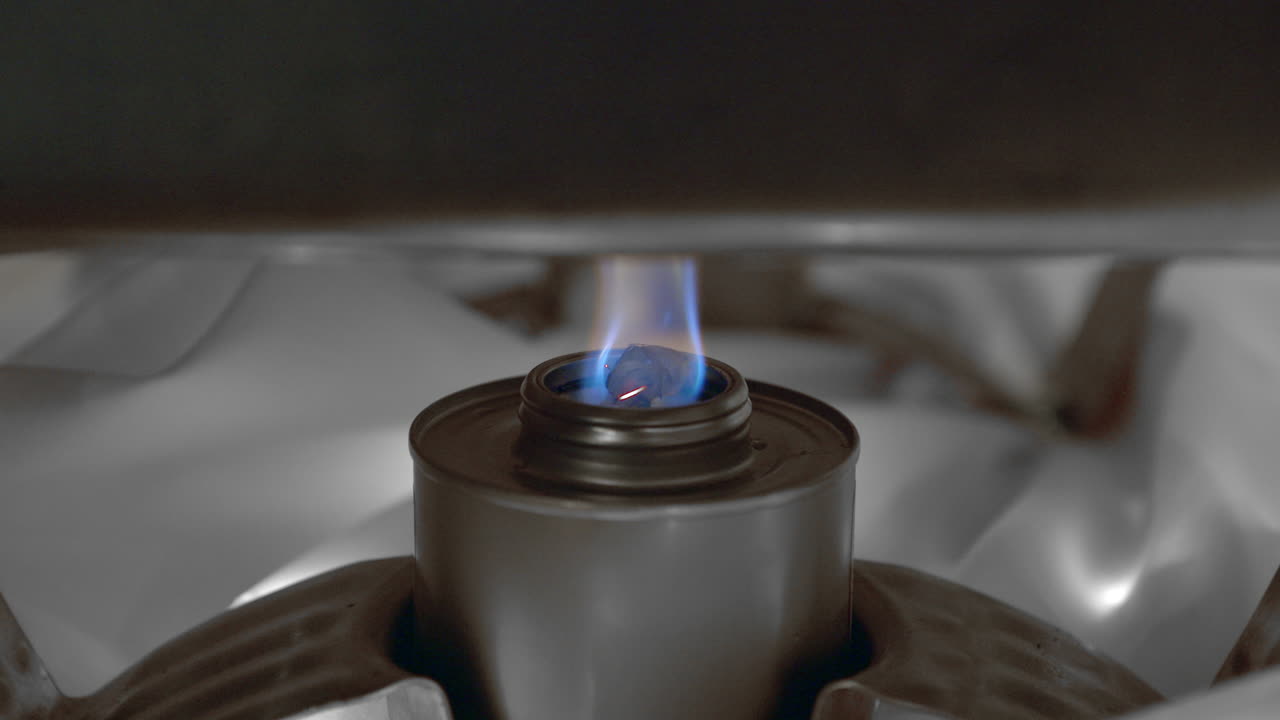 Close up of blue flame burning under restaurant steel serving dish