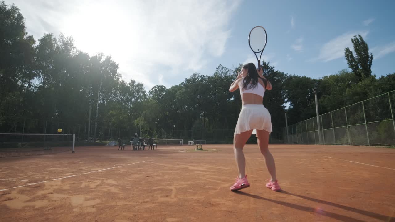 아름다운 테니스 소녀가 야외 코트에서 을 연습하고 있습니다.