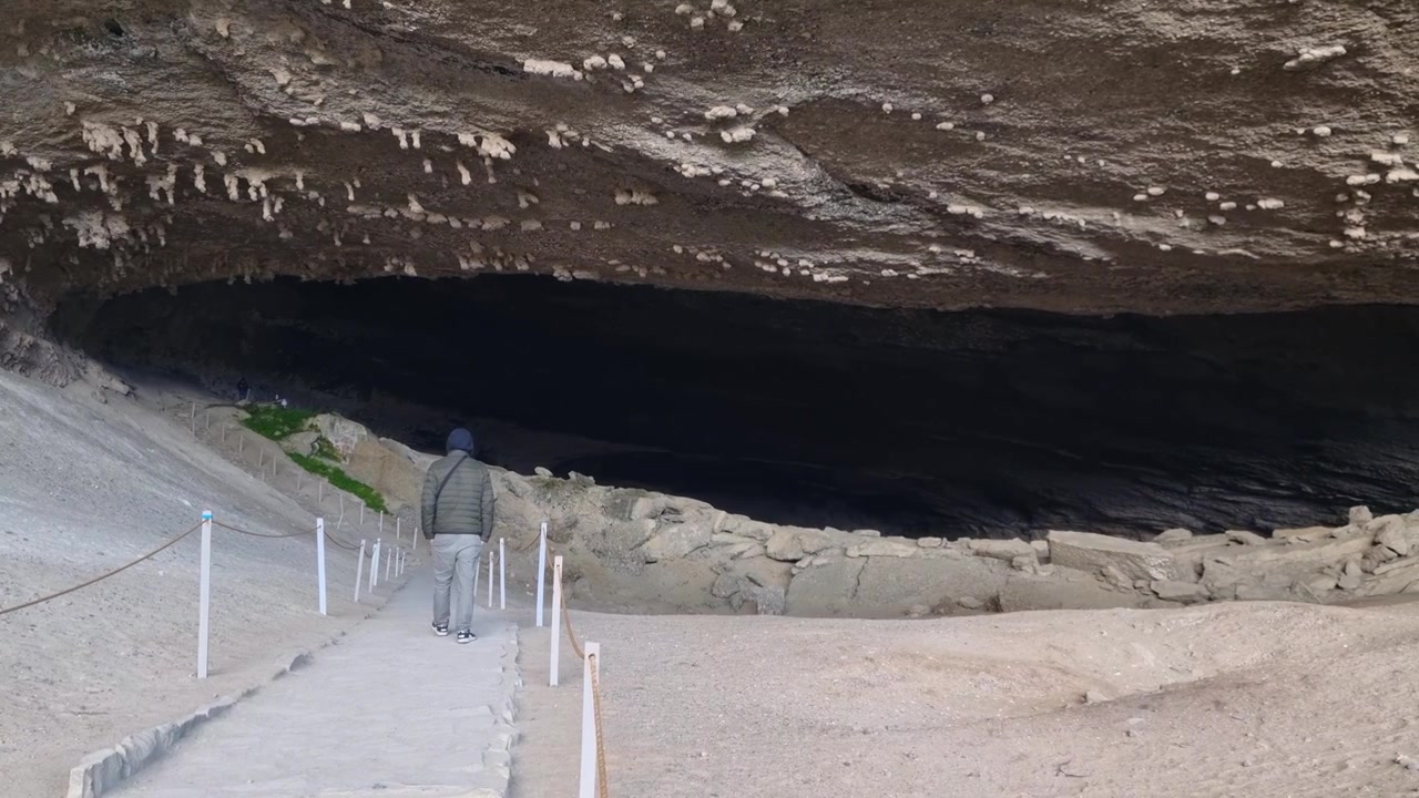 A man explores the famous Cueva del Milodón near Puerto Natales, Chile. Inside the prehistoric cave, dramatic rock formations and the Patagonian wilderness reveal the natural history and rugged beauty