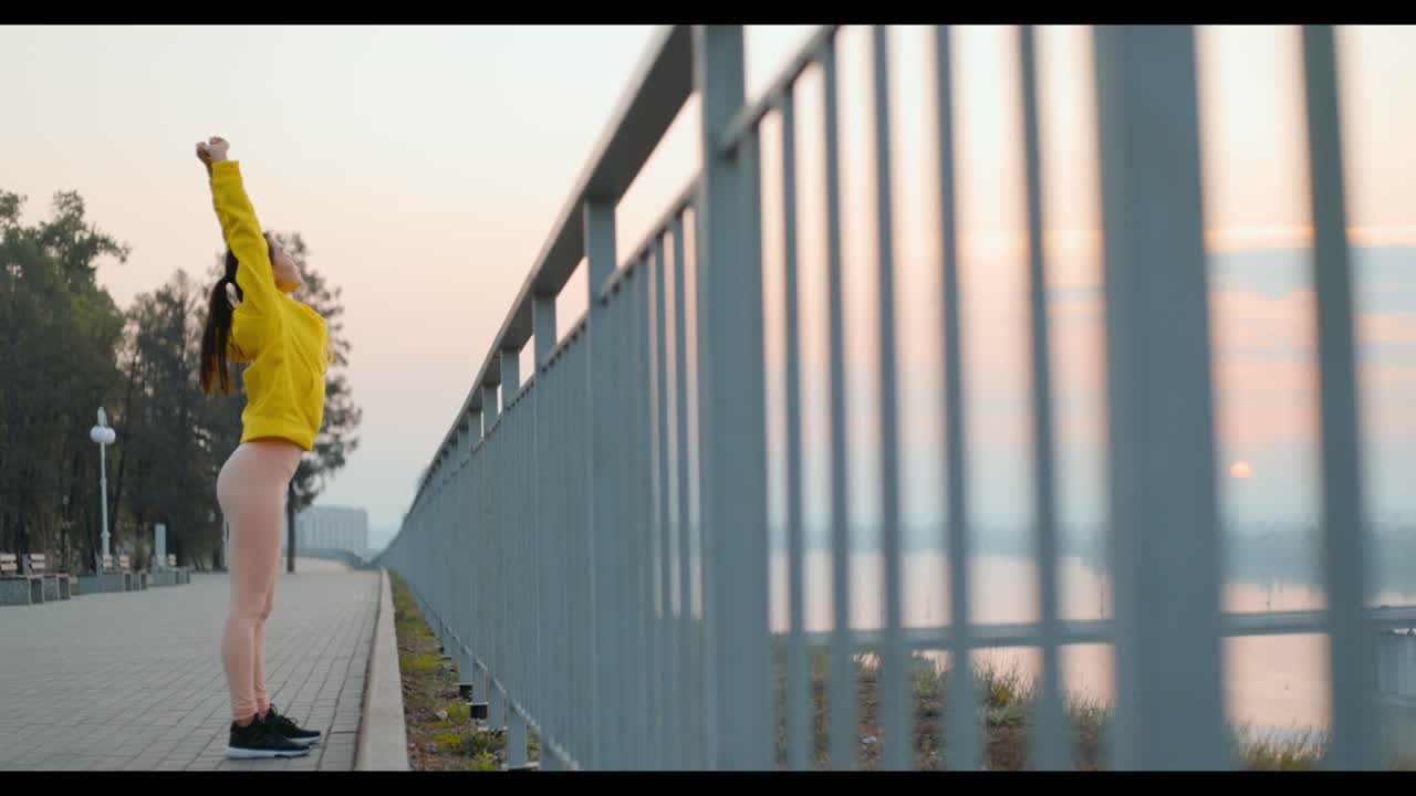 Woman Stretching at Sunrise by the River