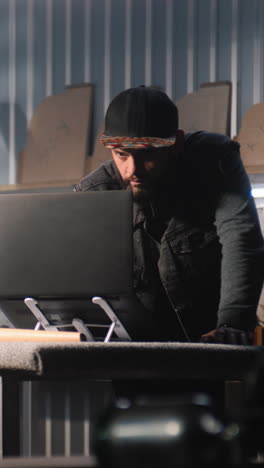 man working on a laptop in a workshop