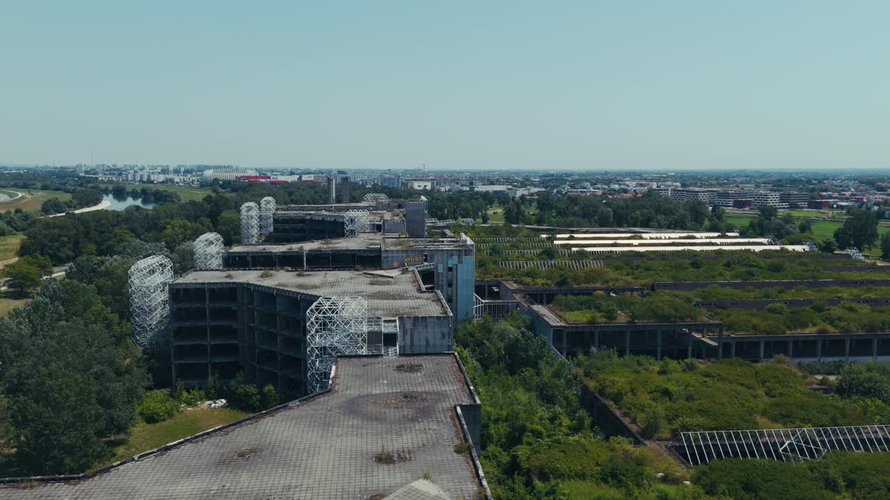 abandoned hospital complex stretches toward river and distant city buildings